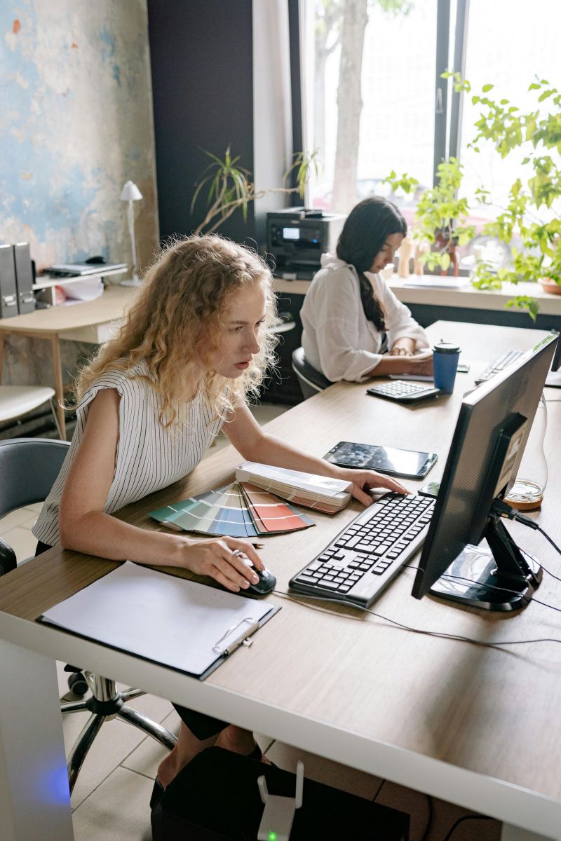 Office team working at desks with laptops and monitors